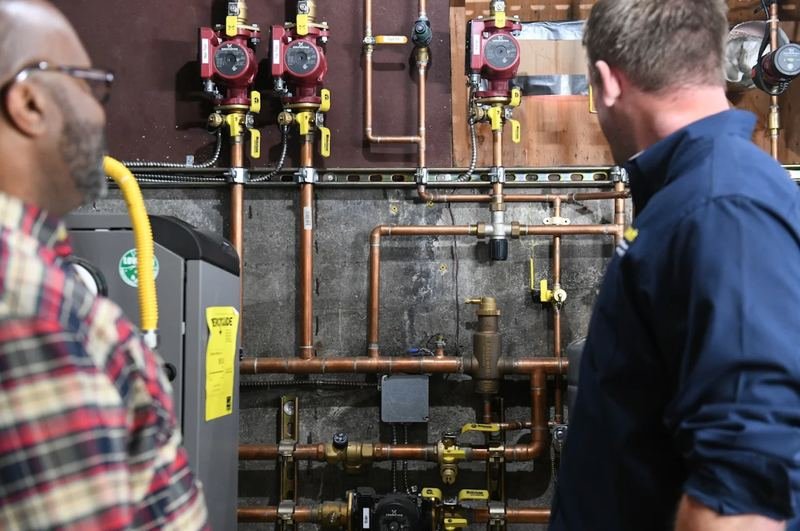 Plumber explaining new boiler piping to a homeowner