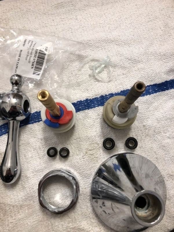 Shower valve cartridges, seats and trim laid out on a towel